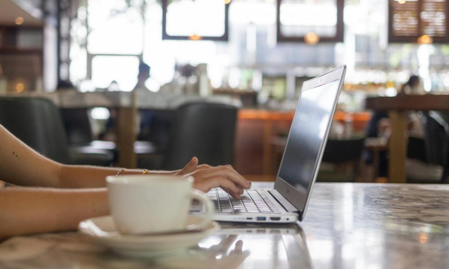 Instructor working one-on-one with participant reviewing personalized financial plan on laptop